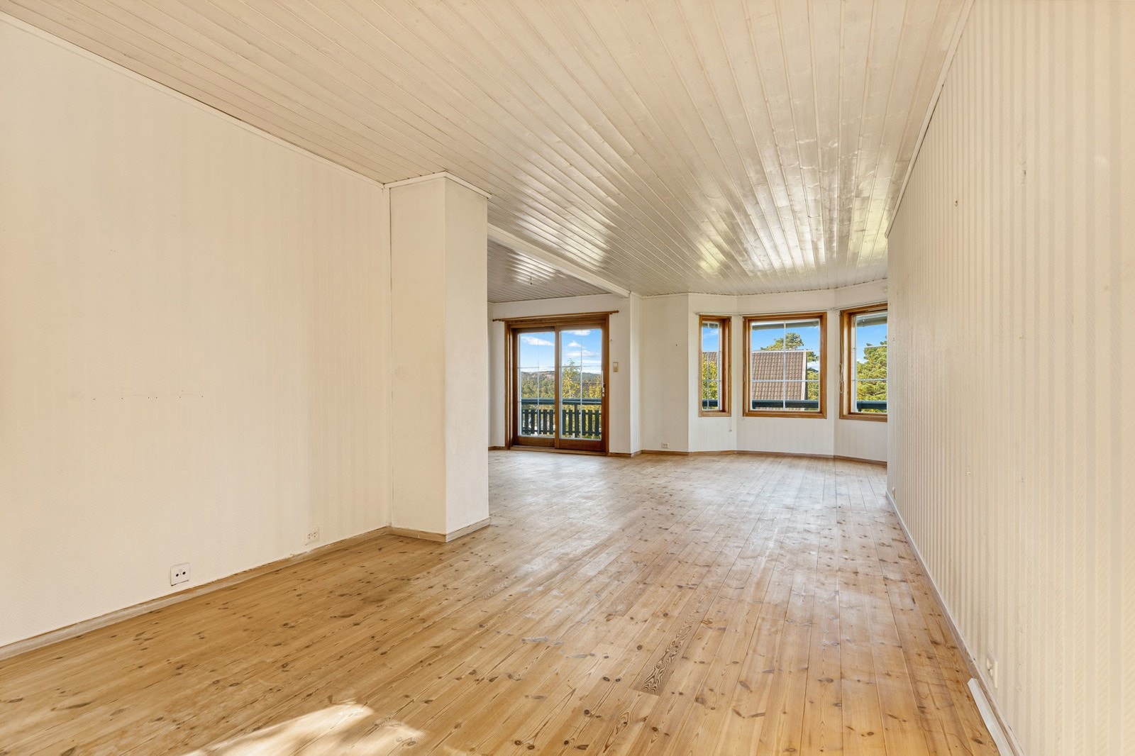 Romslig stue med store vindusflater Galleribilde