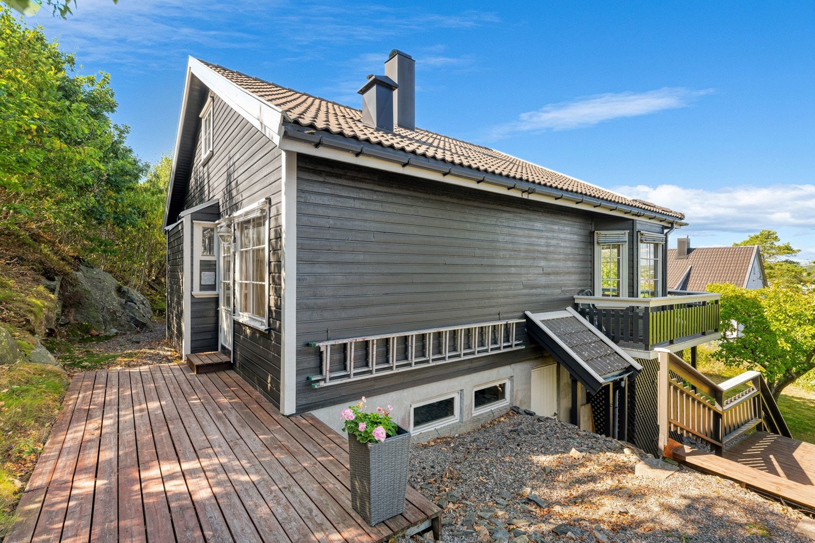 Boligen sett fra siden, med romslig terrasse og gode utearealer. Galleribilde