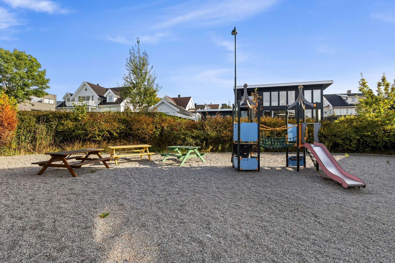 Borettslagets felles lekeplass med klatrestativ, rutsjebane og benker. Galleribilde