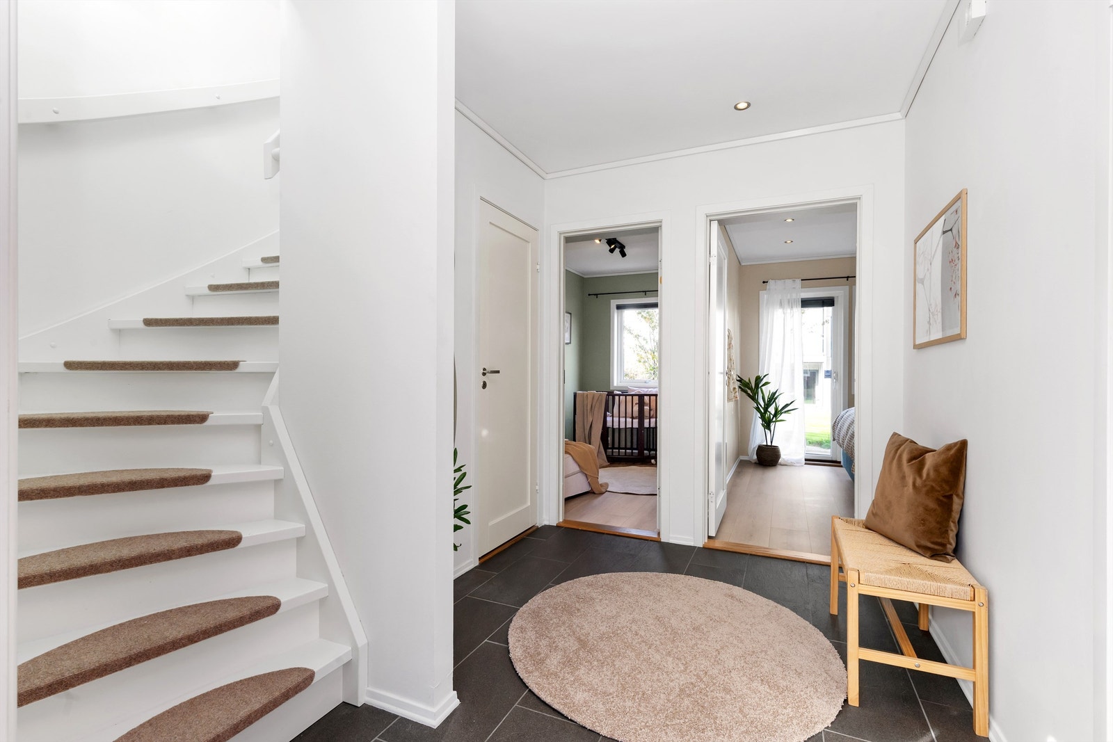 Trapperom med hvitmalt tretrapp som leder opp til oppholdsrommene i andre etasje. Galleribilde