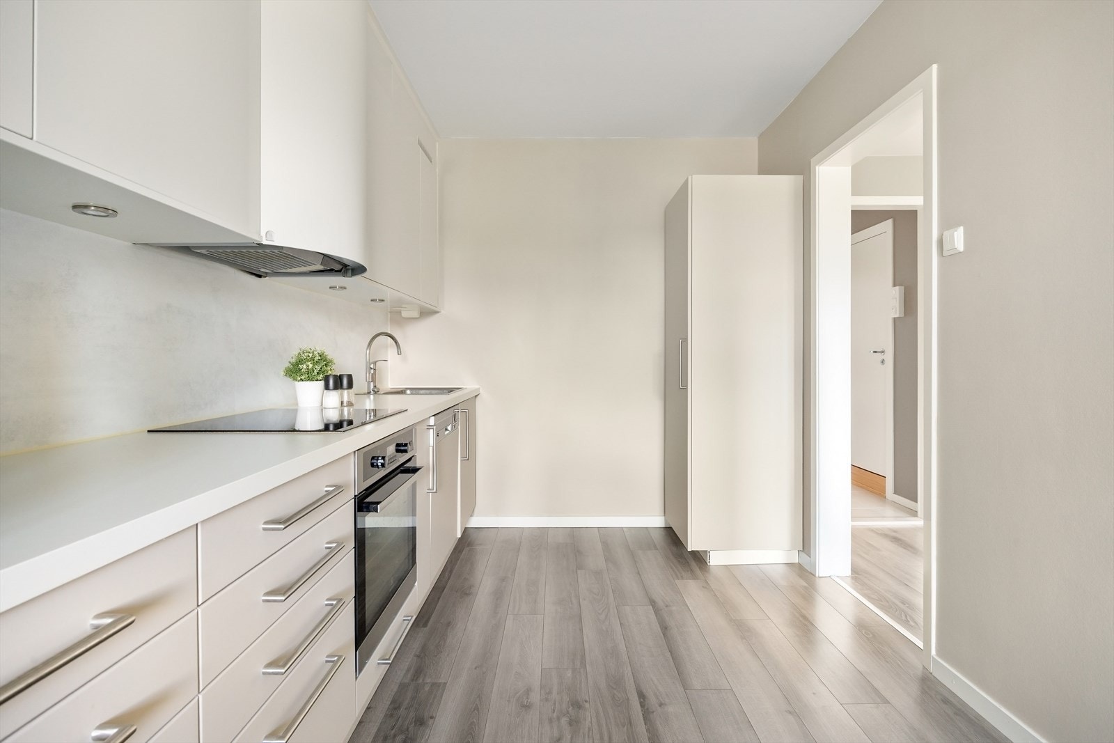 Kjøkkeninnredningen består av glatte fronter og laminert benkeplate, integrert koketopp, stekeovn, oppvaskmaskin og nedsenket oppvaskkum. Galleribilde