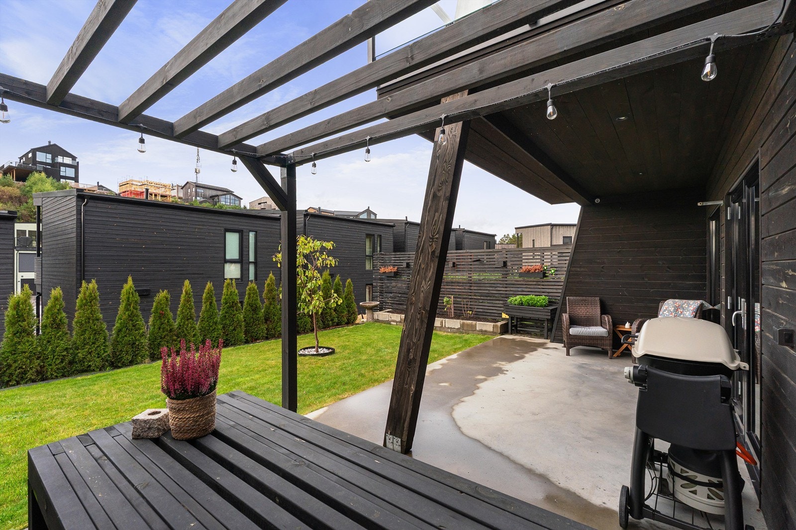 Overbygd terrasse med pergola og hyggelig uteplass mot hagen Galleribilde