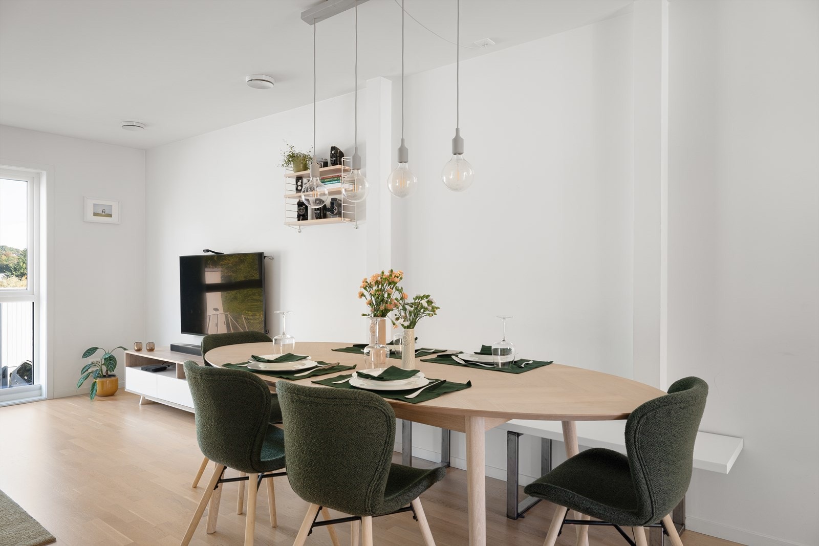 Her er det god plass til både sofagruppe og spisebord, noe som skaper et naturlig samlingspunkt for familie og gjester. Galleribilde