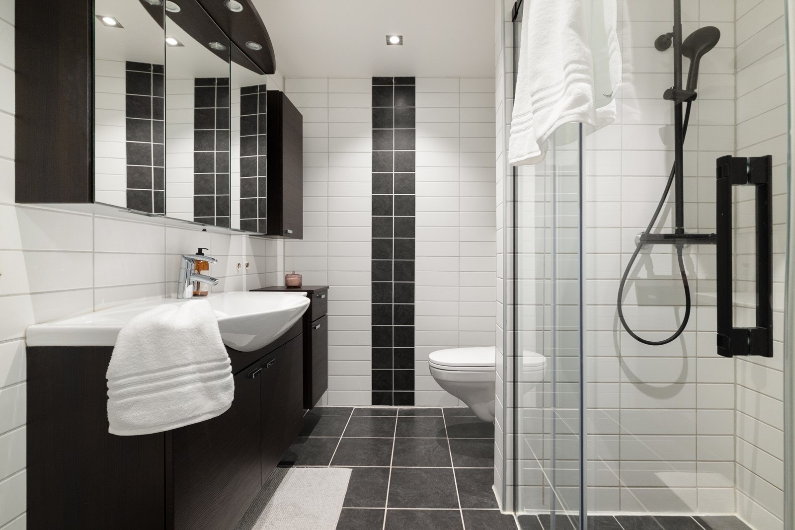 Flislagt bad som ble oppgradert i 2010. Badet har gulvvarme og er innredet med vegghengt servantskap med ovenpåliggende servant, speilskap med belysning og toalett. Galleribilde