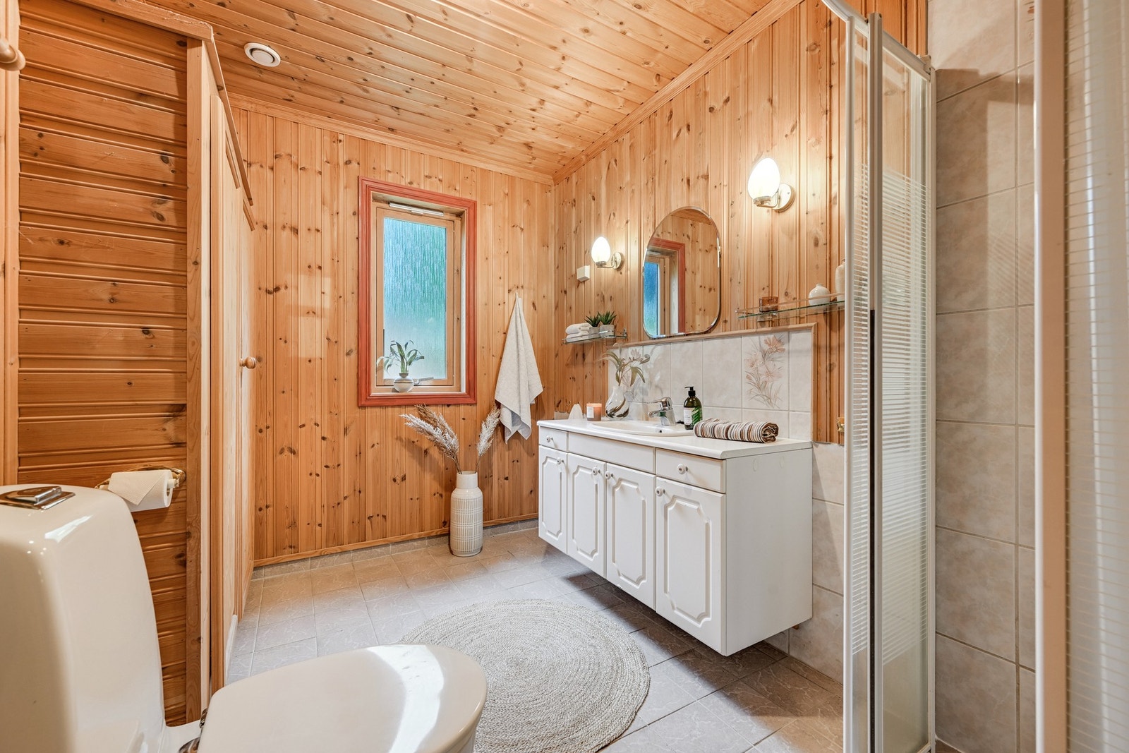Badet er innredet med dusjkabinett, servantinnredning og toalett. Galleribilde