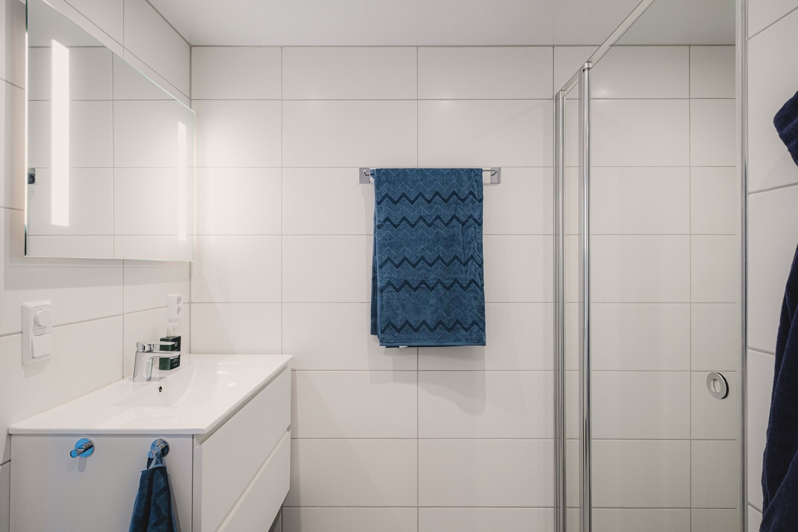 Badet har servantinnredning med brede skuffer for oppbevaring og speil med integrert belysning. Galleribilde