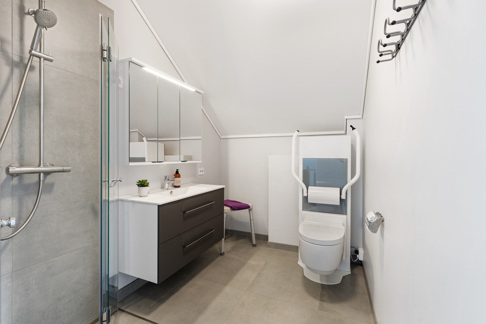 Badet ble helrenovert i 2025 og har flislagt gulv, gulvvarme og regndusj. Galleribilde