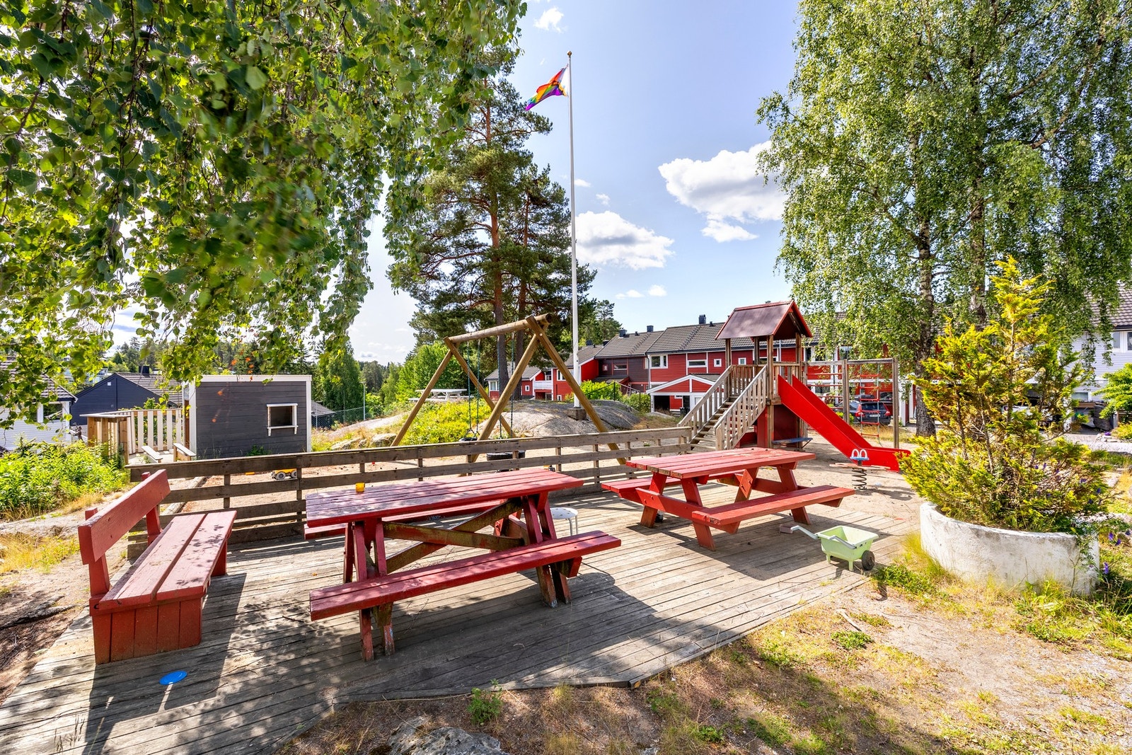 Stort tun med lekeapparater og sittegrupper til felles anvendelse. Galleribilde
