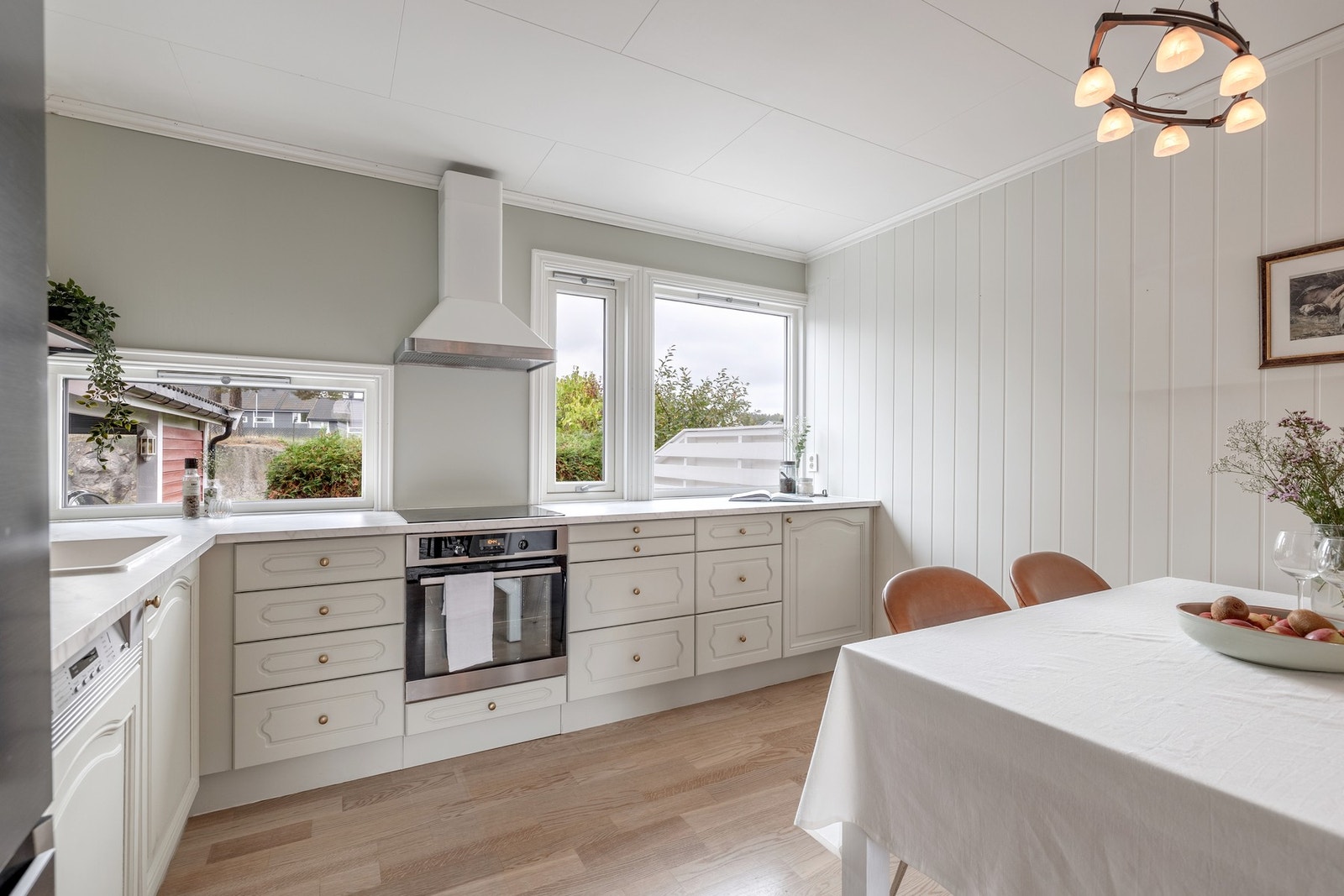 Kjøkkenet har et klassisk design med malte profilerte eikefronter og lys laminatplate med nedfelt kum. Galleribilde