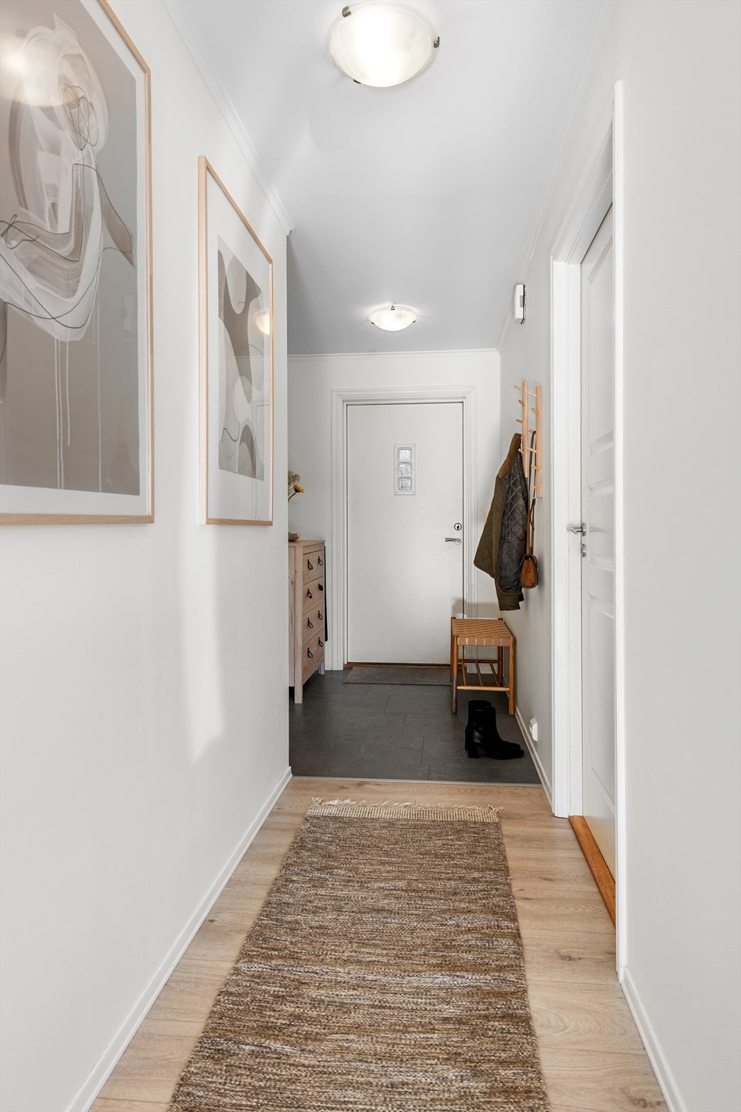Entrédøren har glassfelt og sikkerhetslås, og gangen binder rommene fint sammen. Galleribilde