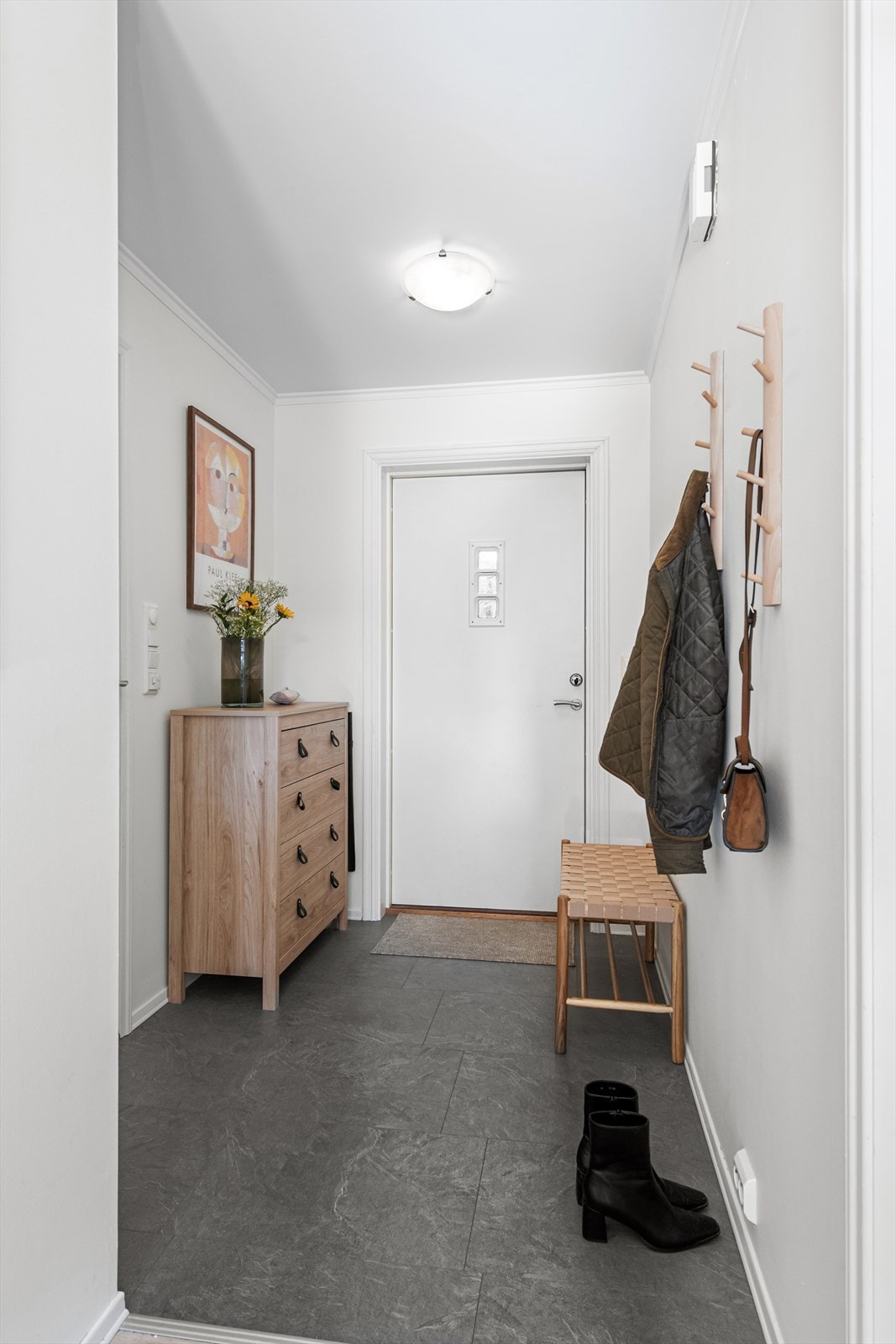 Entré med praktiske laminatfliser på gulvet og plass til klesoppheng. Galleribilde