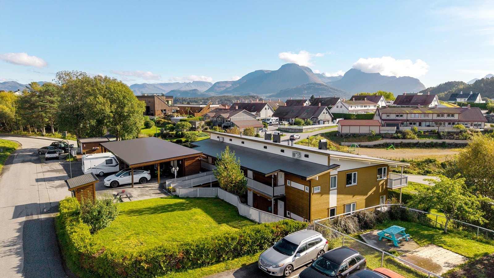Etablert boligmiljø med felles plen, lekeområde og storslått utsikt mot Sunnmørsalpene. Galleribilde