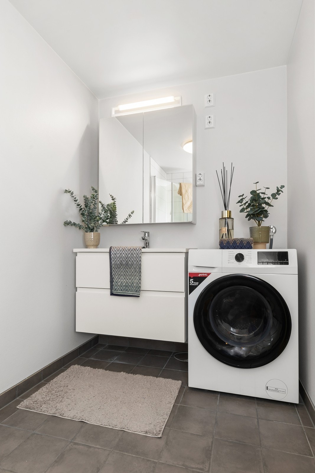 Badet er ellers utstyrt med dusjhjørne, vegghengt toalett og baderomsinnredning med nedfelt servant. I tillegg har man opplegg for vaskemaskin. Galleribilde