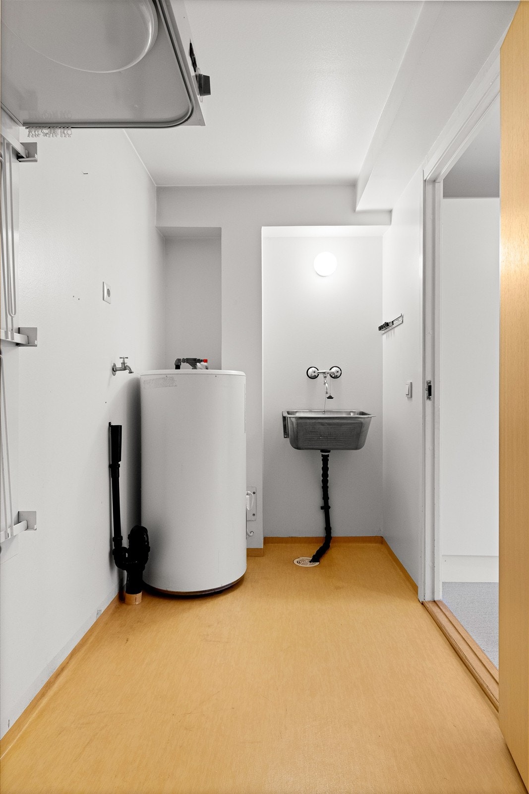 Praktisk separat vaskerom med utslagsvask, opplegg for vaskemaskin og varmtvannsbereder. Galleribilde