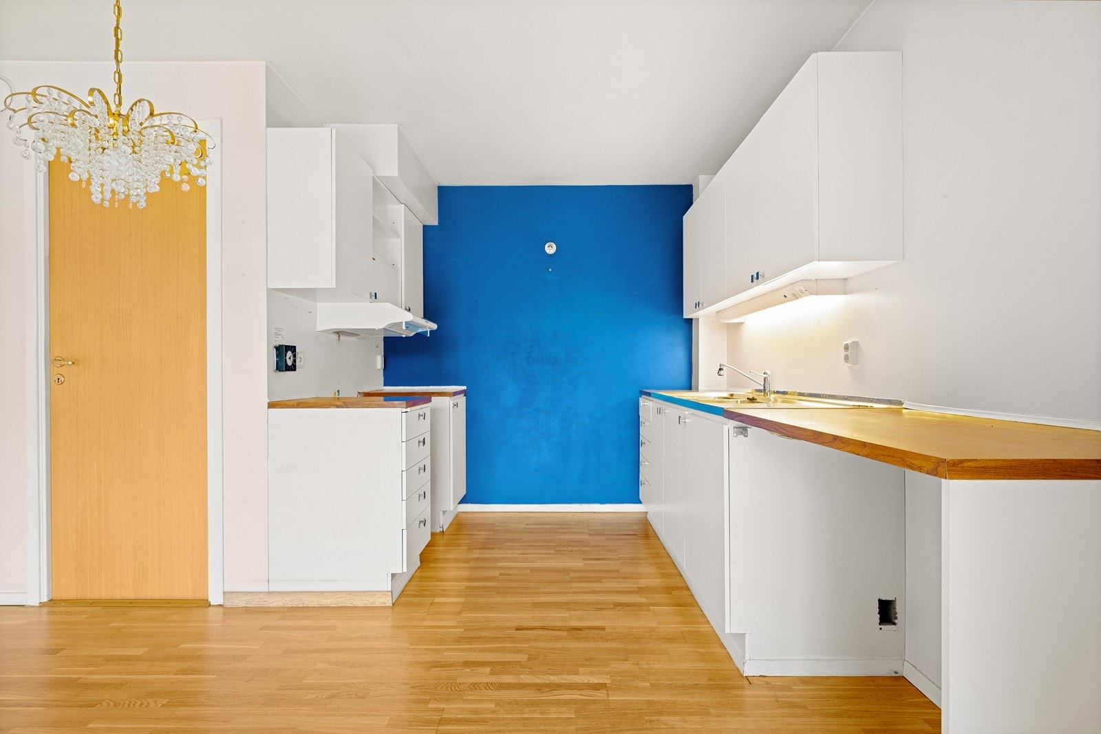 Kjøkkeninnredning med glatte fronter, ventilator i overskap og benkeplate i laminat med god belysning. Galleribilde