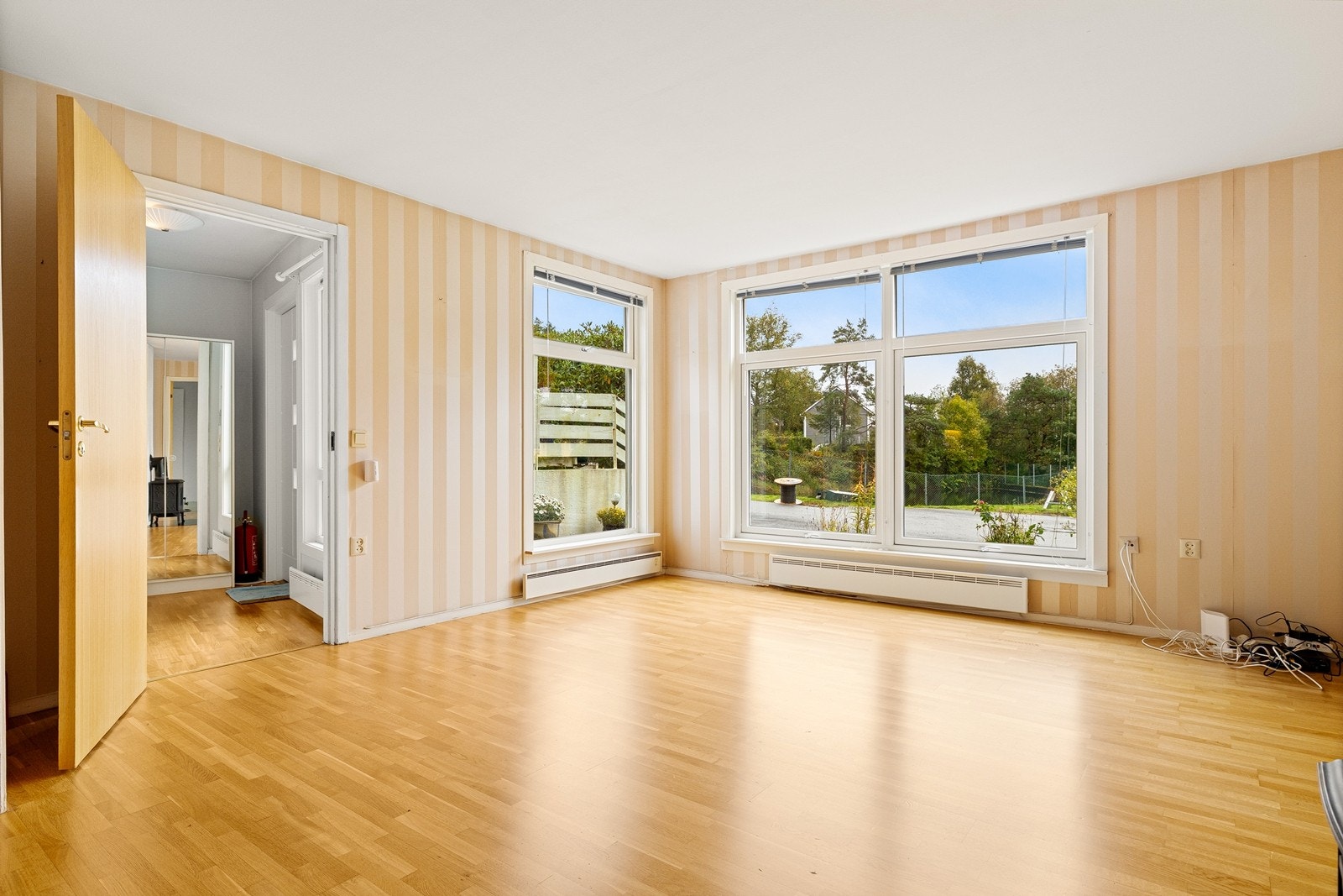 Lys stue med parkett på gulv og vinduer fra 2019. Galleribilde