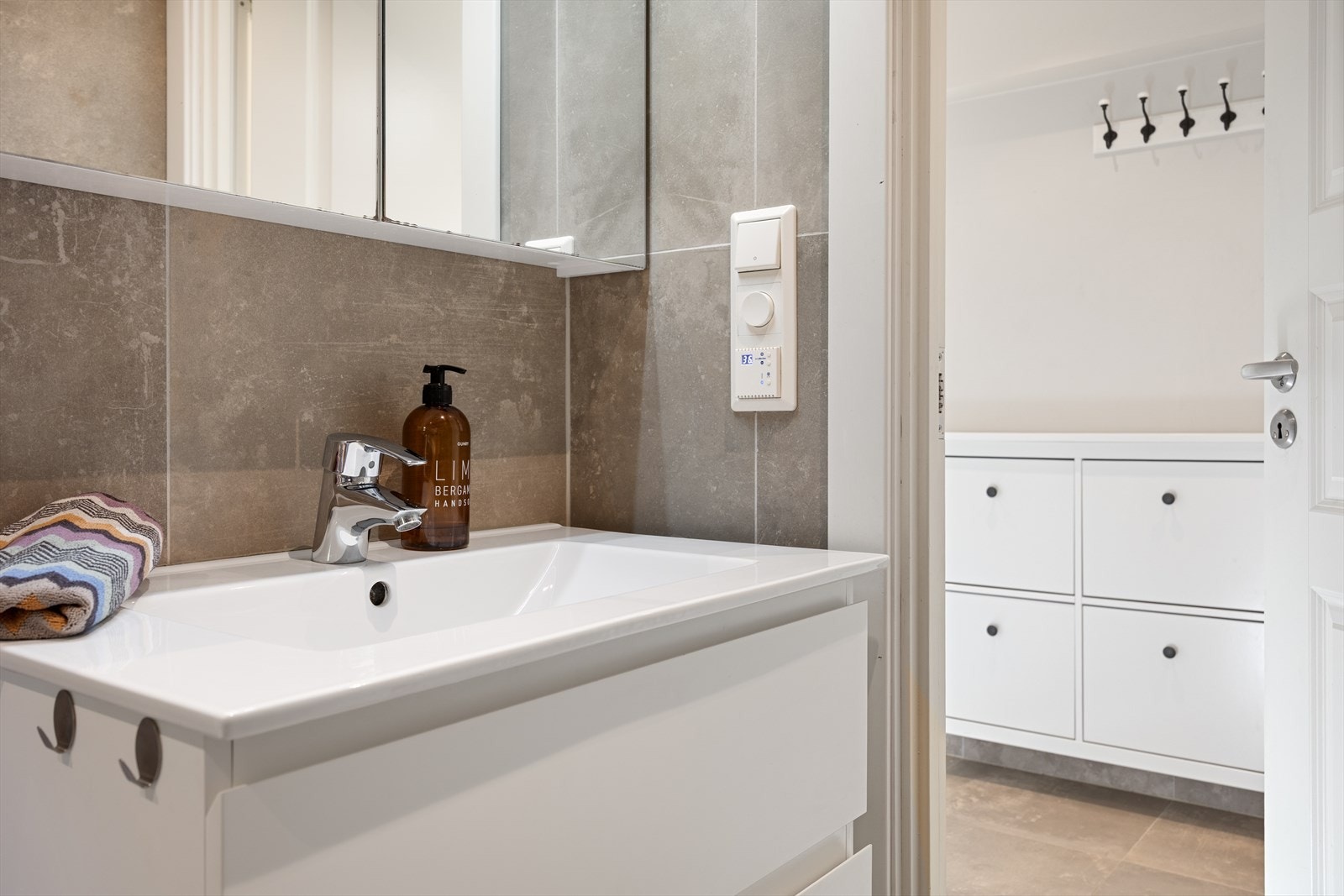 Badet ble pusset opp i 2020 og er innredet med vegghengt toalett, dusjhjørne med glassdører, servant med underskap og speilskap. Galleribilde
