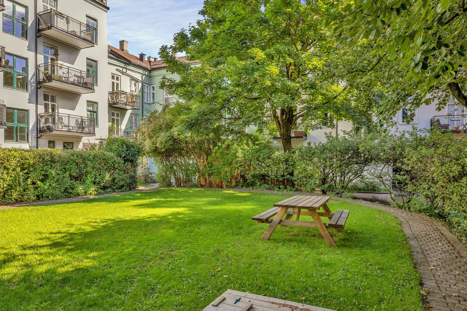 Grønn og flott bakgård som nærmest oppleves som borettslagets egen park Galleribilde