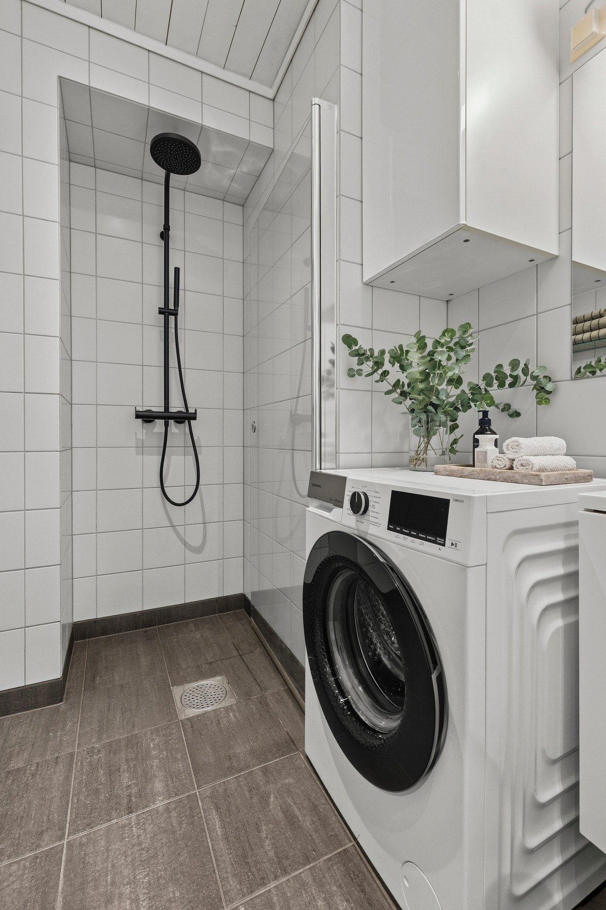 Rommet er funksjonelt innredet med vegghengt toalett, servantskap med nedfelt servant, speil på vegg og opplegg for vaskemaskin. Galleribilde