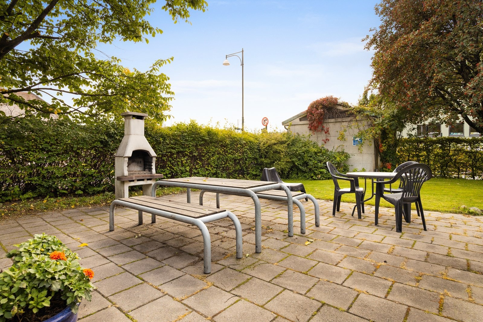 Sosialt uteområde med grillplass og flere sittebenker. Galleribilde