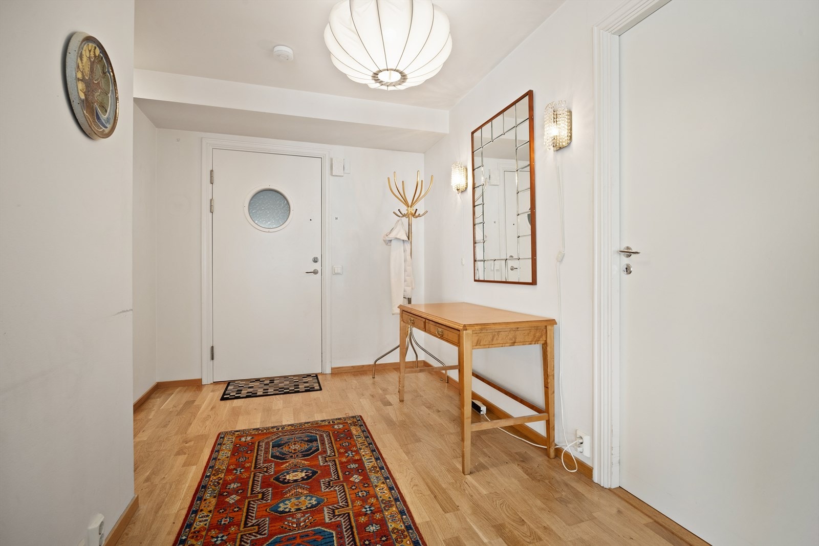 Romslig entré med lyse overflater, parkett på gulvet og god plass til smart oppbevaringsløsninger. Galleribilde
