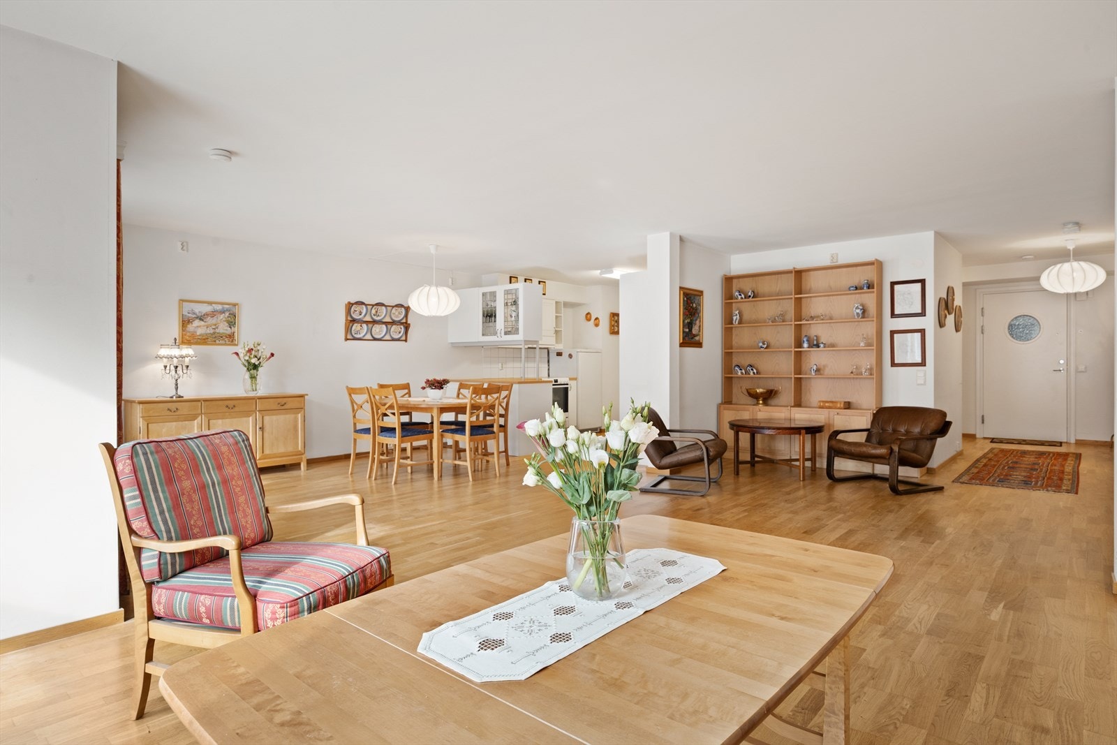 Allrommet har store vinduer og dør ut til balkongen, samt overflater med parkettgulv og lysmalte veggflater. Galleribilde