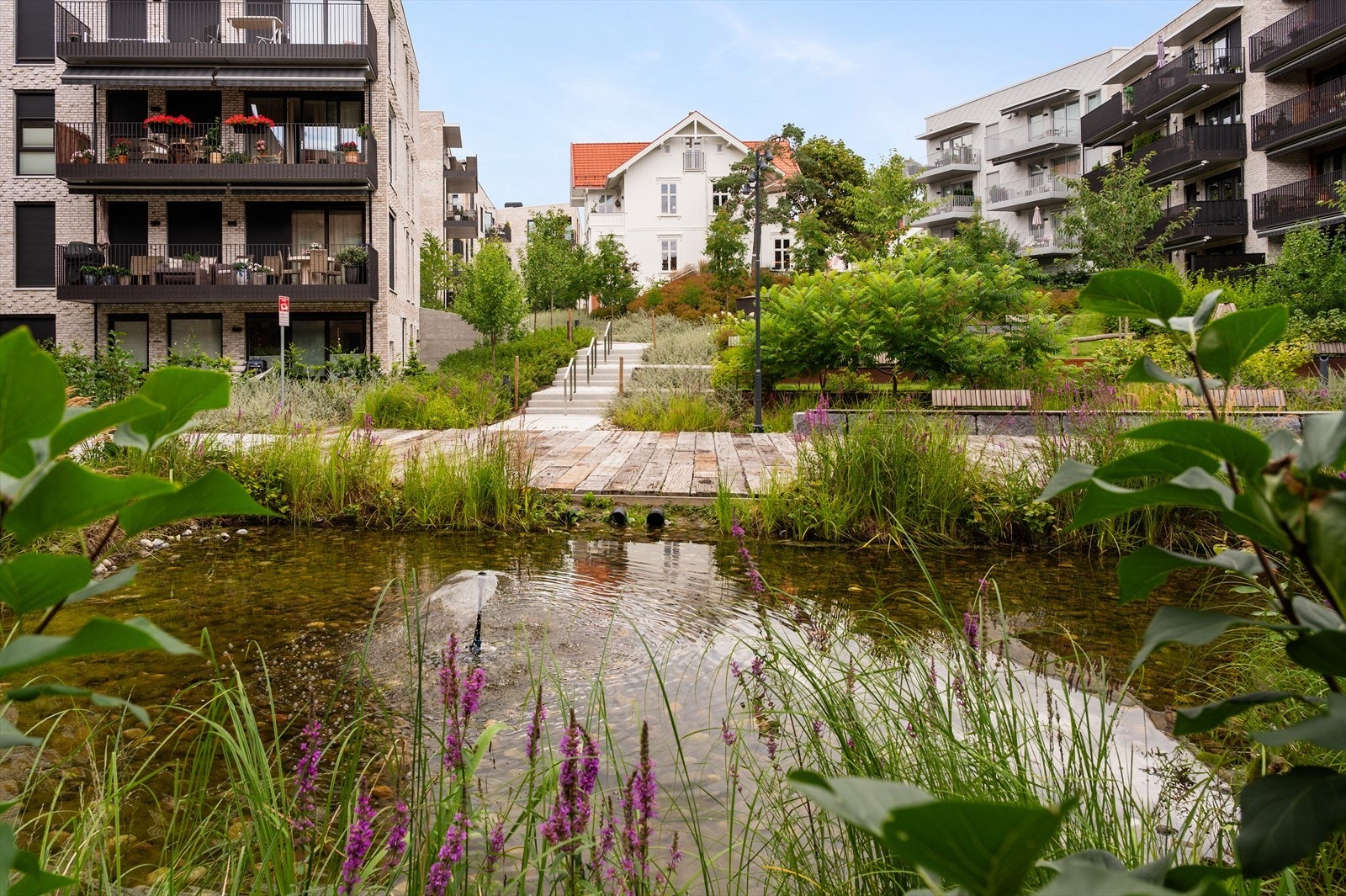Fellesområdene er pent opparbeidet, her med hyggelig vanndam med koselig beplantning rundt. Galleribilde