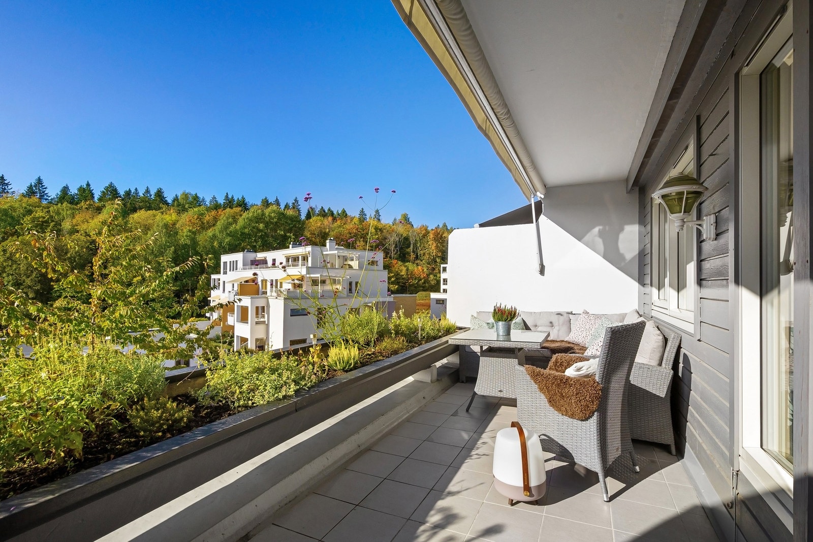 Vestvendt balkong med blomsterkasse og god plass til sittegruppe. Galleribilde