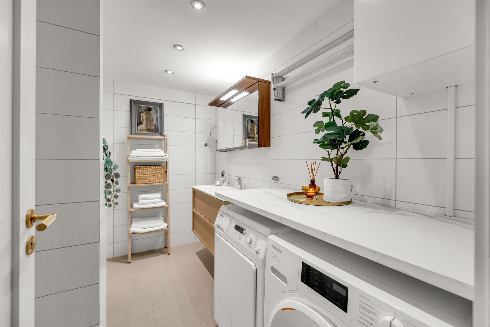 Leiligheten har et romslig hovedbad med badekar og opplegg for vaskemaskin og tørketrommel. Galleribilde