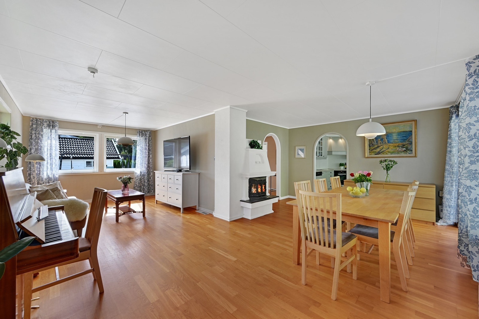 Stuen har god plass til både spisebord og sofagruppe, med et ildsted som midtpunkt.
Foto: Fotofinish AS Galleribilde