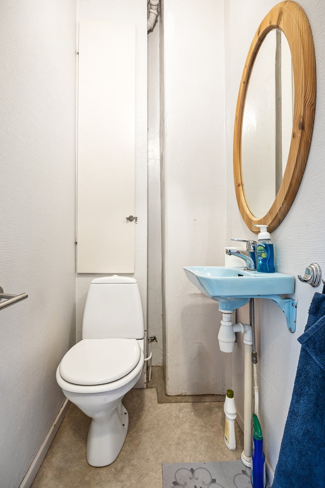 Toalettrom i 1. etasje med gulvstående toalett og vegghengt servant med speil over. Galleribilde