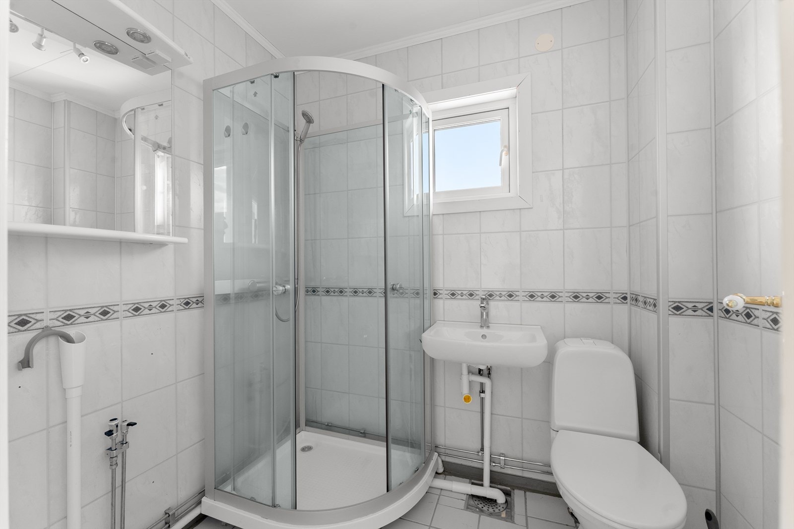 Badet har dusjkabinett, servant, toalett og opplegg for vaskemaskin. Galleribilde