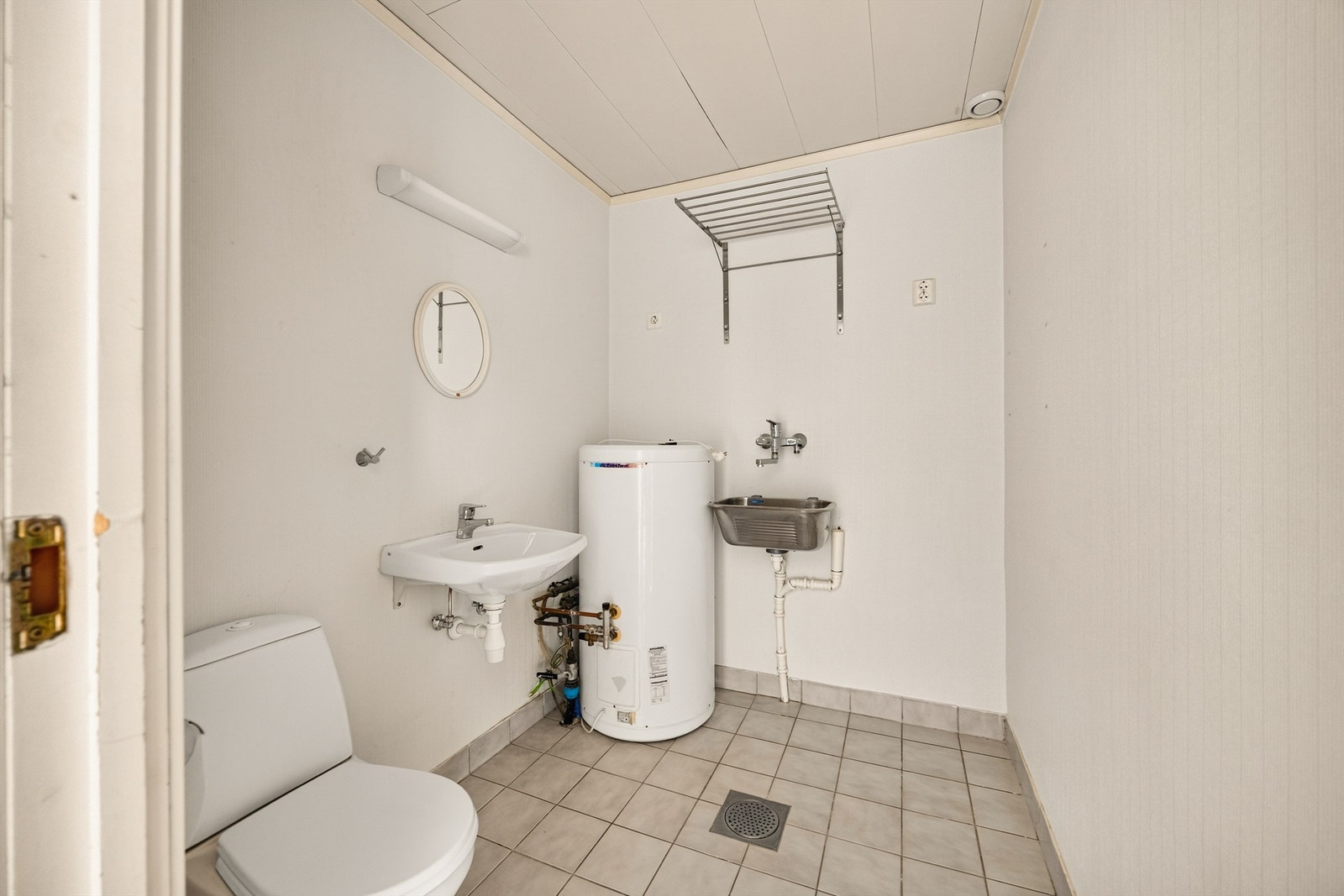 Praktisk vaskerom i første etasje med gulvvarme, gulvstående klosett og opplegg for vaskemaskin/tørketrommel. Galleribilde