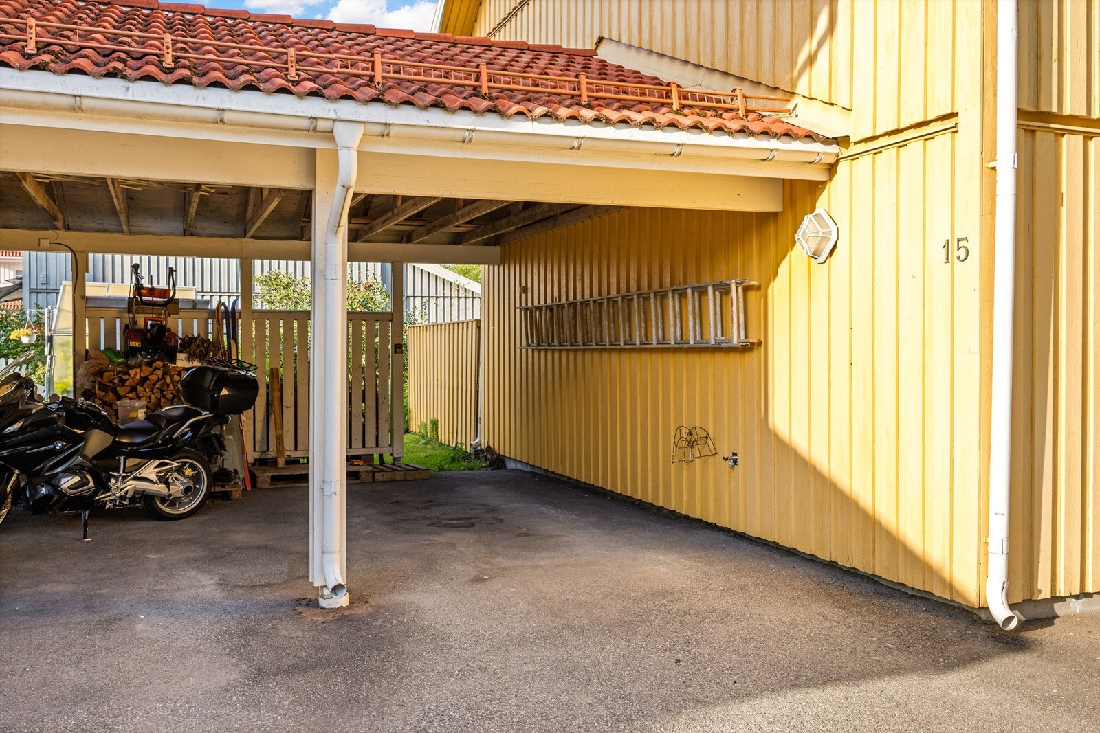 Tilliggende carport med asfaltert gulv og plass til én bil. Galleribilde