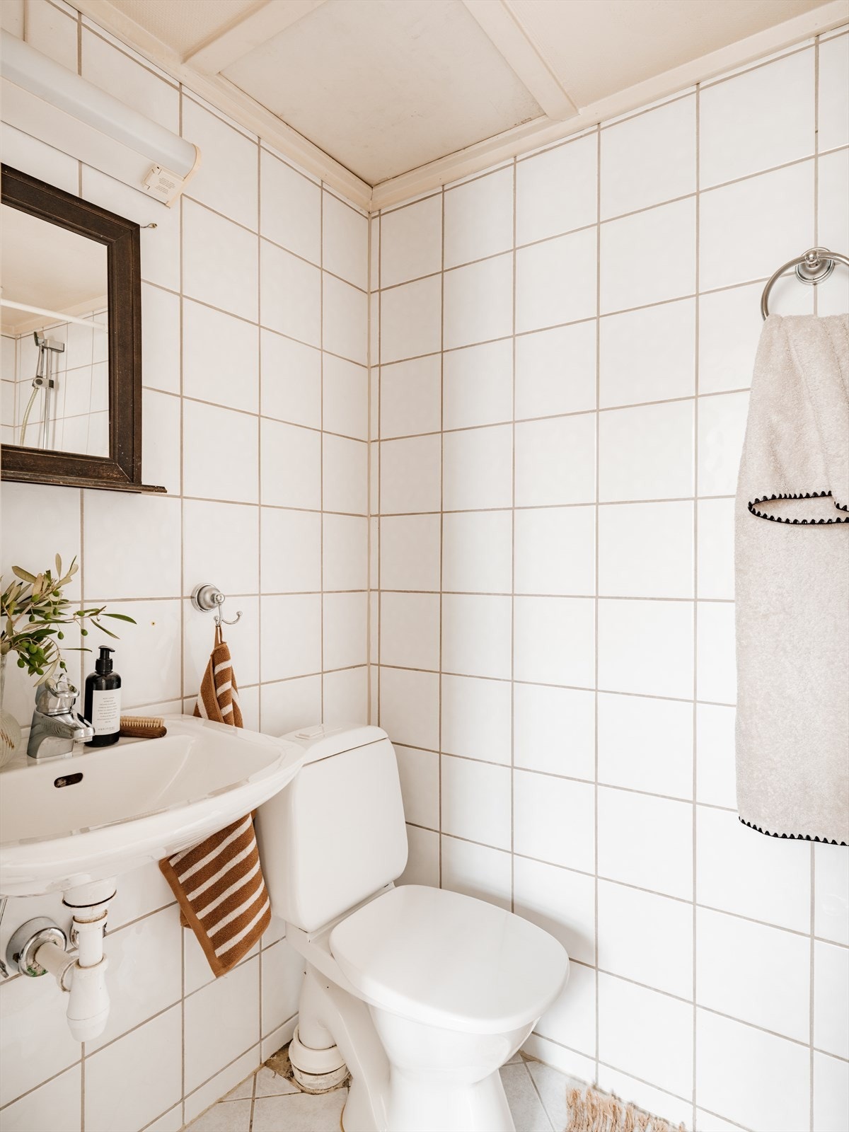 Badet er utstyrt med servant, gulvstående toalett og dusj på gulv. Galleribilde