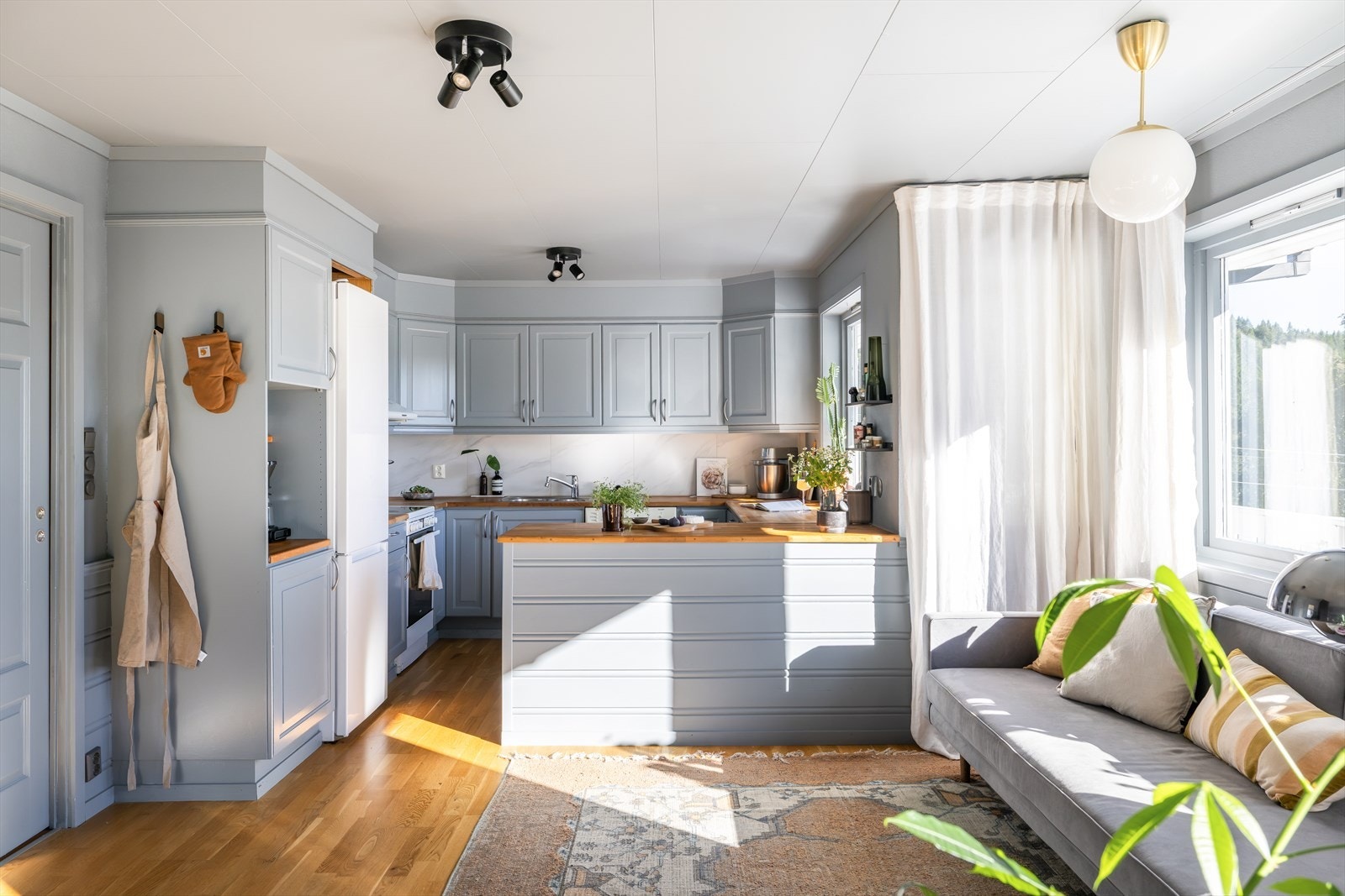 Kjøkkenet er innredet med benkeplate i heltre, nedfelt stålvask og malte, profilerte fronter. Galleribilde