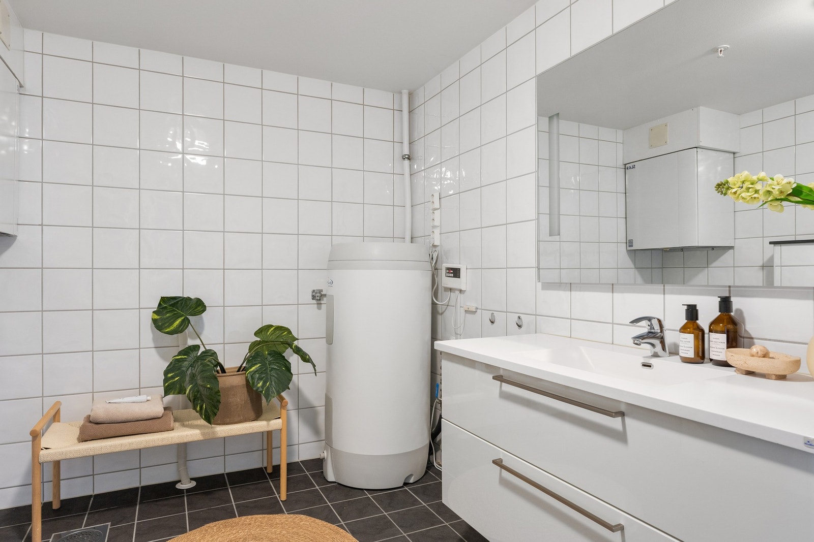 Badet er innredet med dusj, vegghengt toalett og moderne baderomsinnredning, samt opplegg for vaskemaskin. Galleribilde