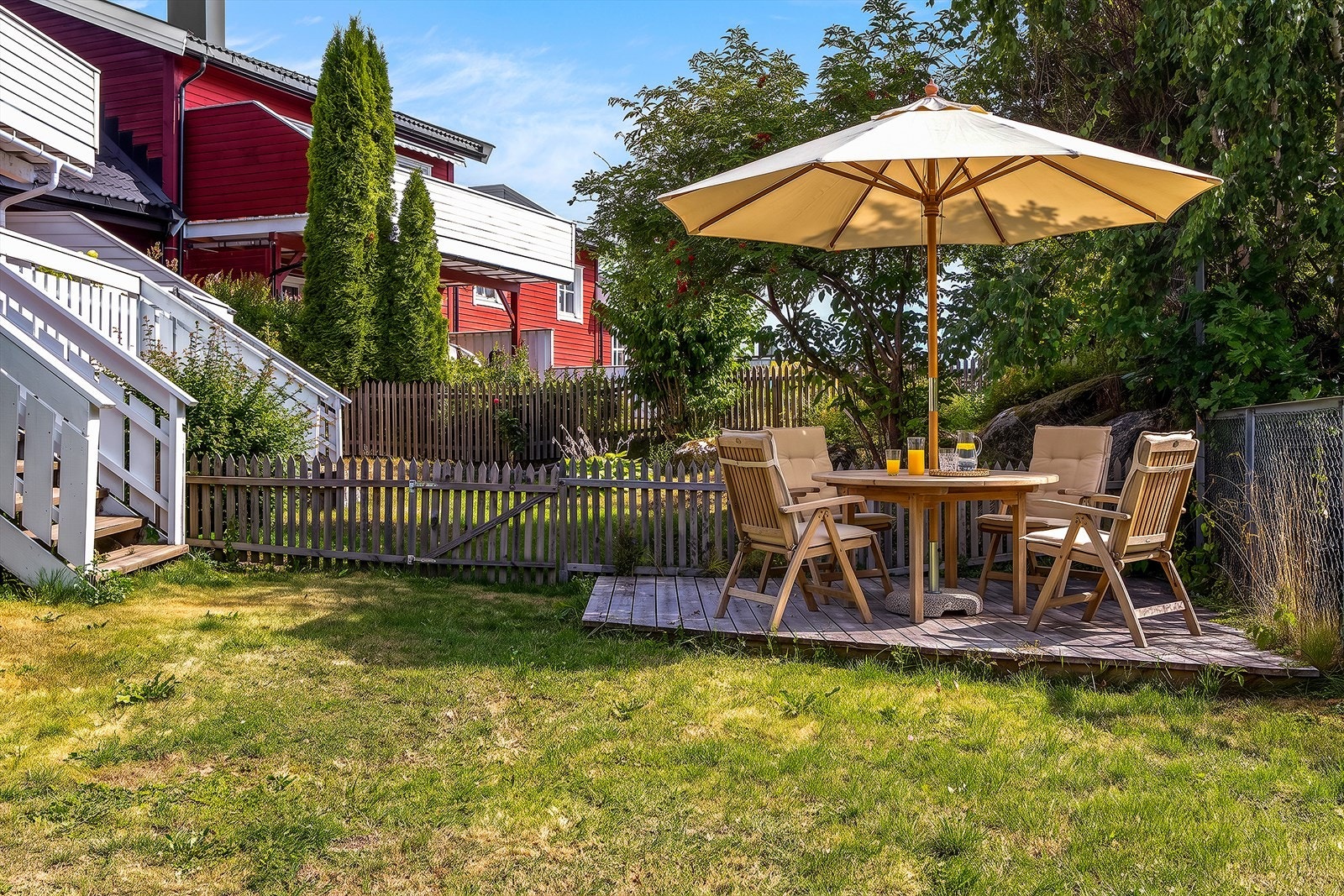 En sydvendt terrasse leder ned til hagen, som byr på gode solforhold langt utover kvelden. Bildet er digitalt møblert. Galleribilde