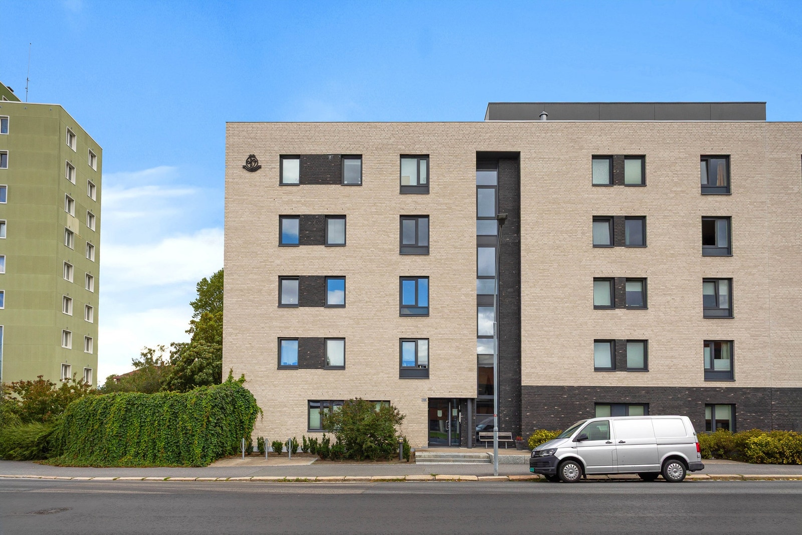 Boligbygget sto ferdig i 2014 og har en moderne arkitektur med teglsteinsfasade og trekonstruksjoner. Et stilrent bygg som glir fint inn i de etablerte omgivelsene. Galleribilde