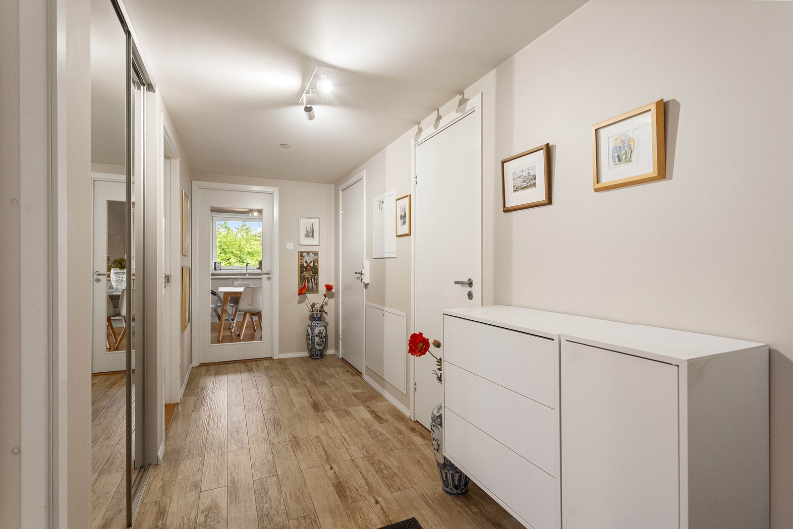 Innbydende entré med flislagt gulv, vannbåren gulvvarme og en romslig skyvedørsgarderobe med speilfronter Galleribilde