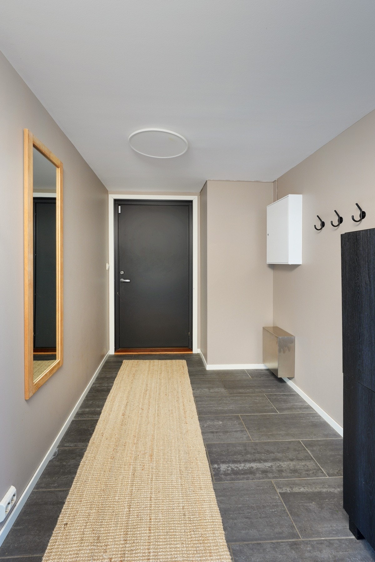Romslig entré med fliser på gulv. God plass til stor garderobe her. Galleribilde