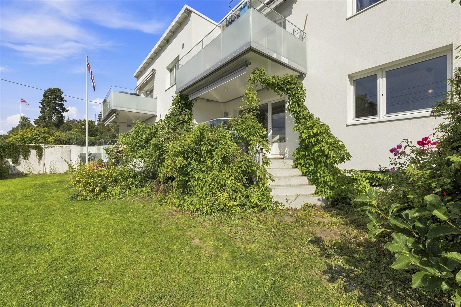 Den frodige felleshagen byr på et grønt og hyggelig uterom med god plass til å nyte sommerdagene. Galleribilde