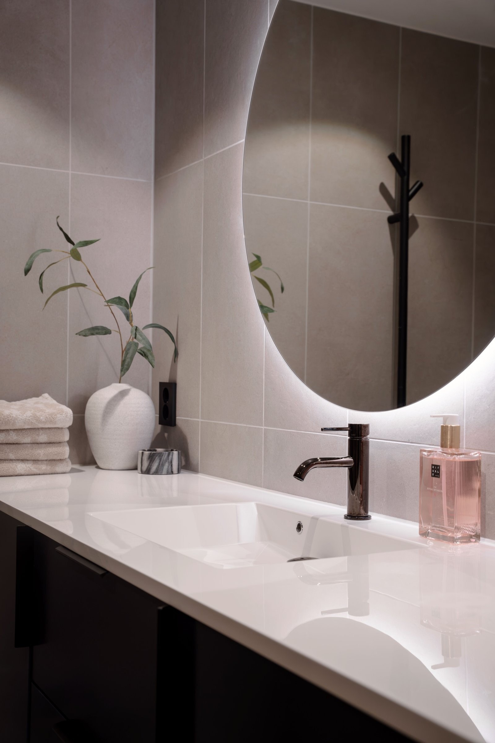Rød tråd i leiligheten med Tapwell black chrome armatur på både bad og kjøkken. Elegant Ø90 speil med LED lys. Galleribilde