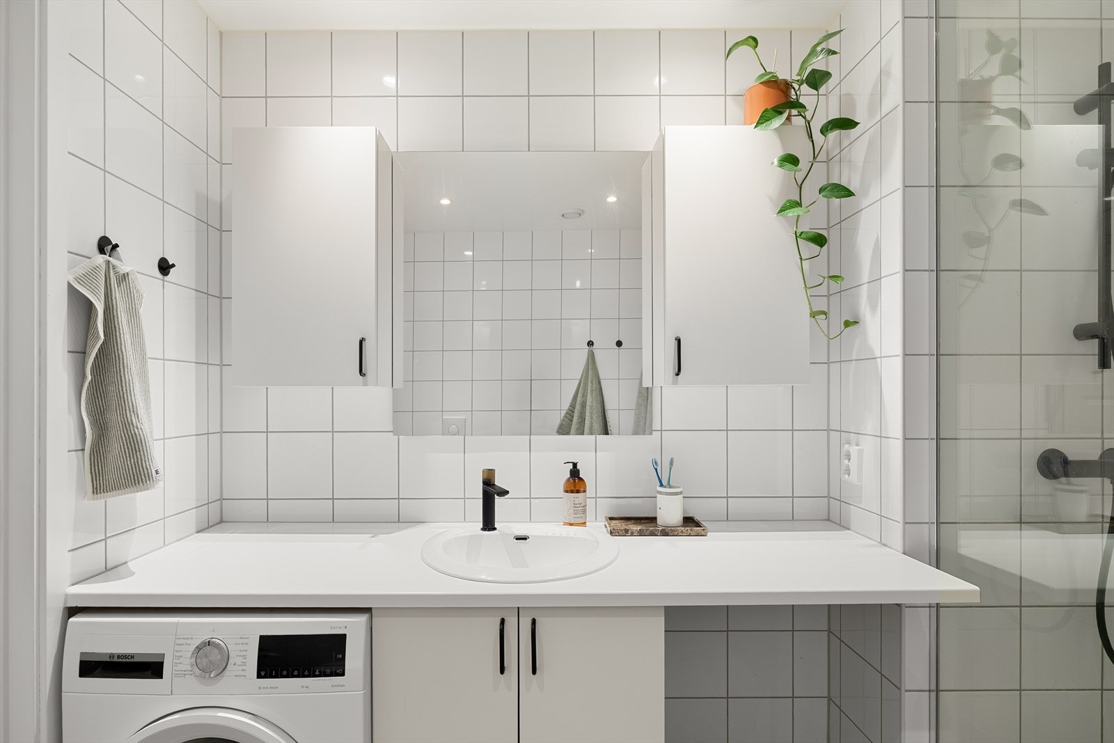 Innredning bestående av innfellbare dusjdører, servantskap og wc. Galleribilde