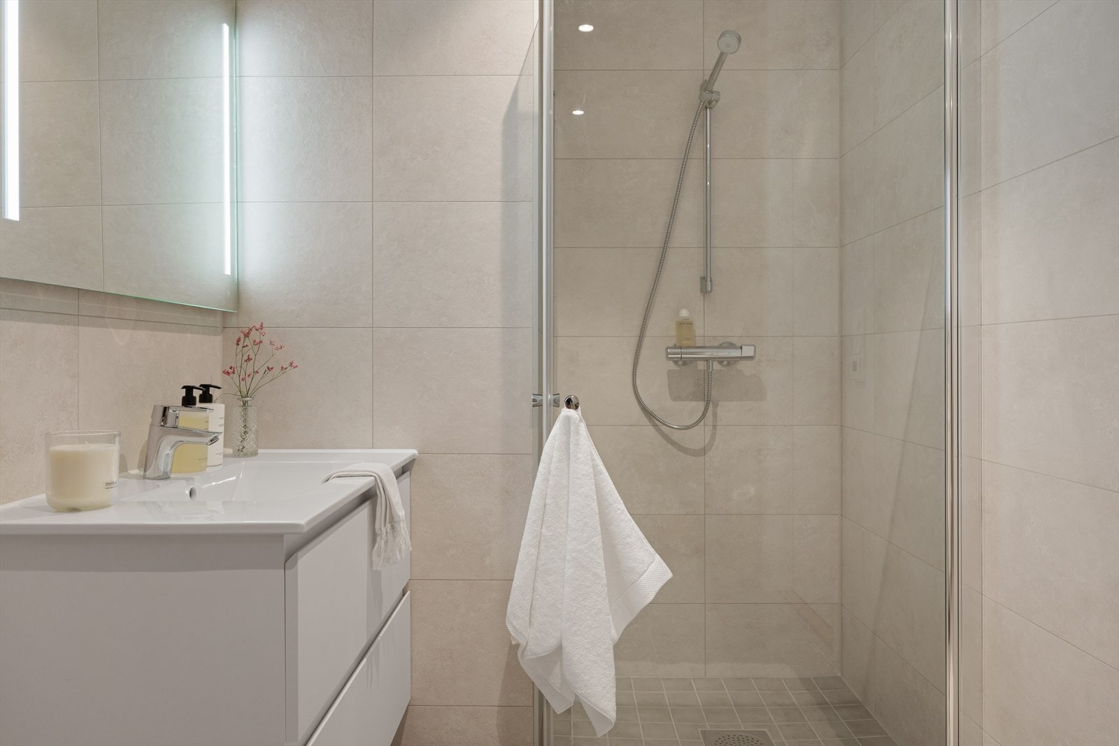 Badet har flott servantinnredning med skuffer, stort speil med integrert belysning Galleribilde