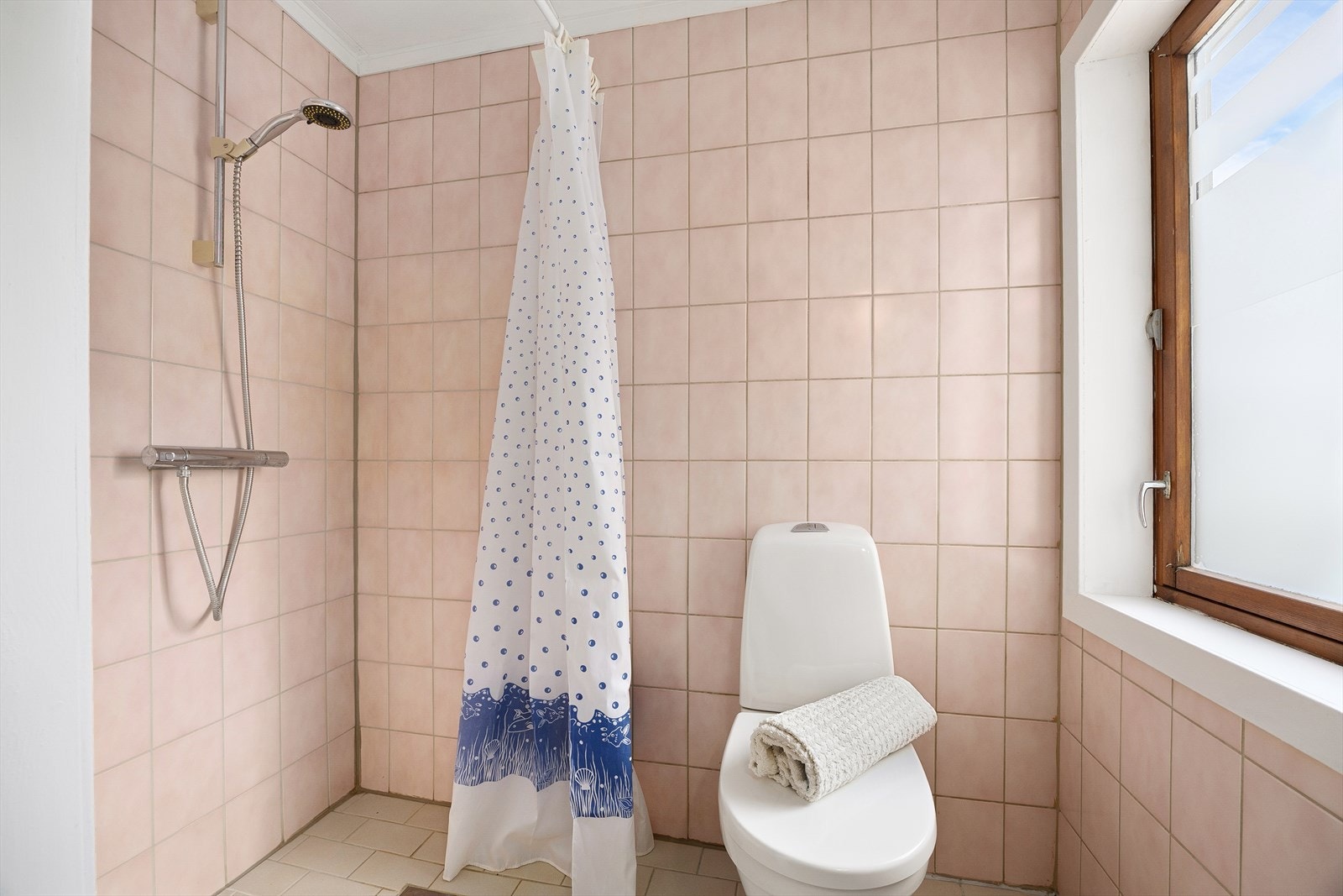 Badet er utstyrt med innredning med nedfelt servant, vegghengt speil, dusjhjørne og toalett Galleribilde