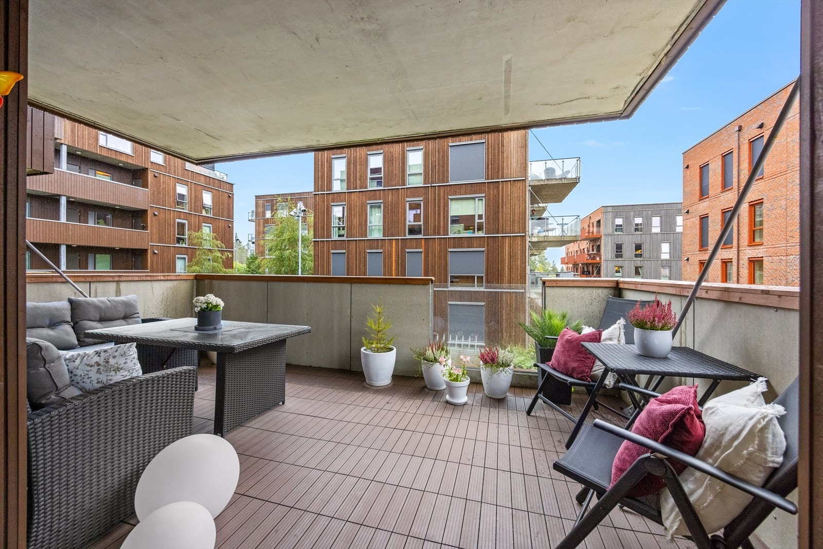 Fra stuen er det direkte utgang til en sør-vestvendt og overbygget balkong på hele 17 m² med god plass til flere koselige møbleringssoner, pent omkranset av et moderne rekkverk av tre, metall og innfelt glass. Galleribilde