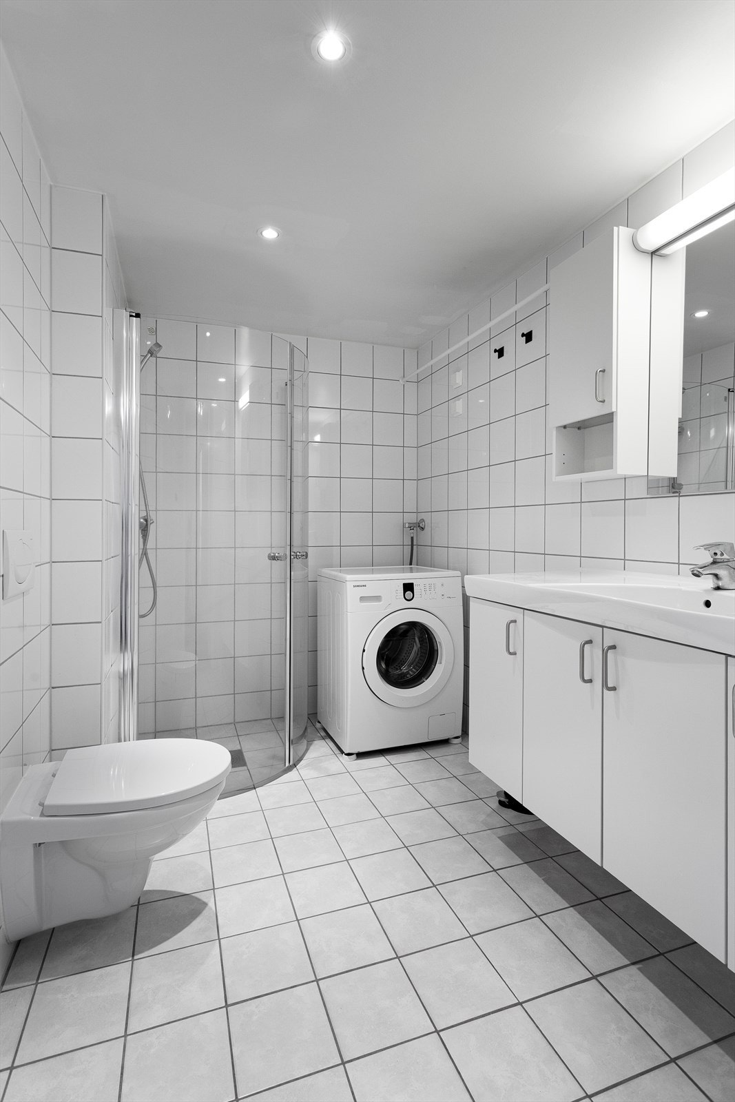 Flislagt bad med elektrisk gulvvarme og downlights i tak. Galleribilde