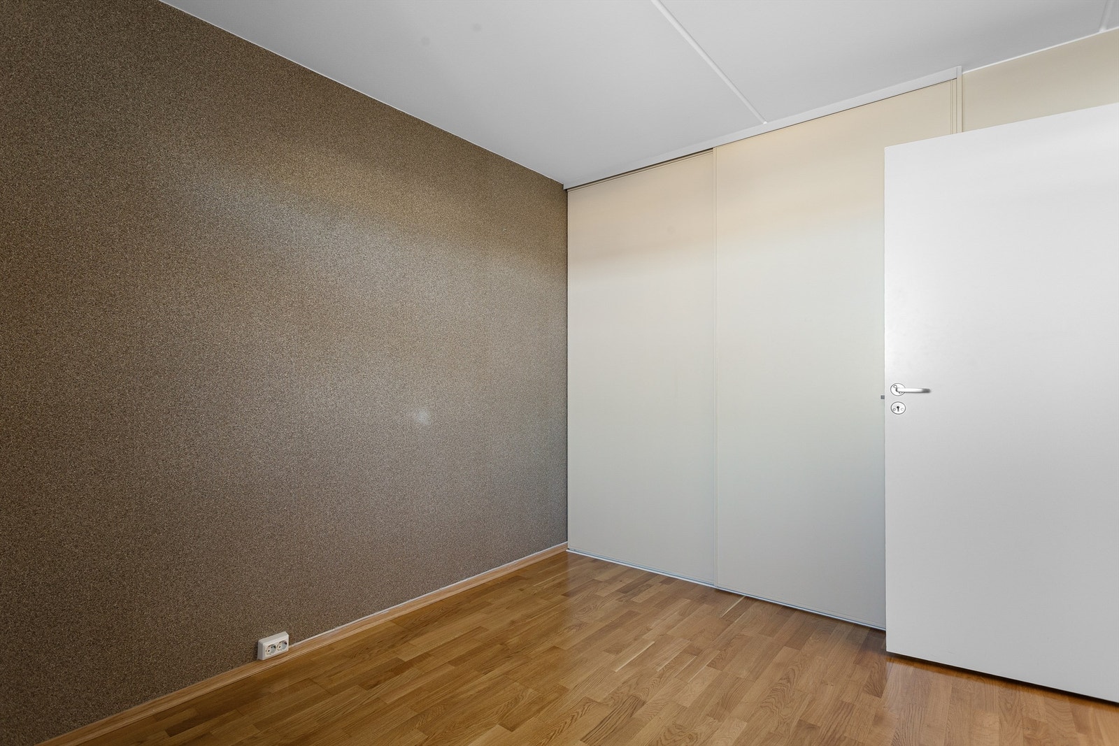 Rommet har innebygget skyvedørsgarderobe i glatt utførelse. Galleribilde
