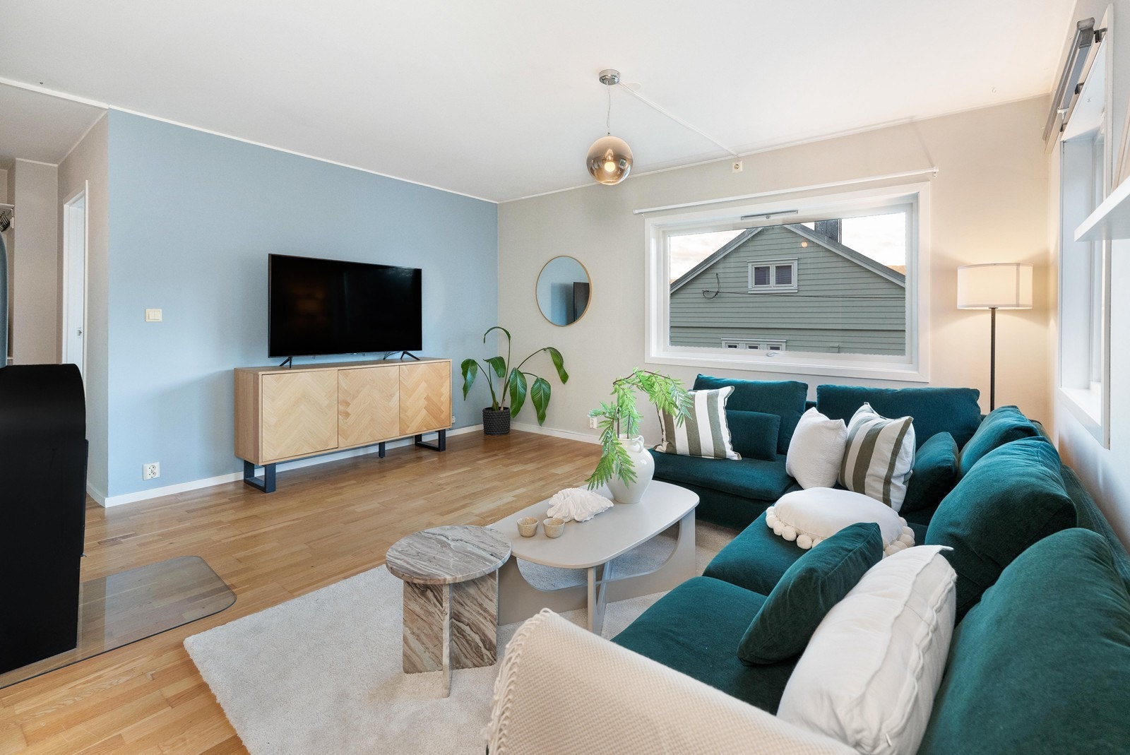 Stuen fremstår som lys og trivelig, med parkett på gulv og lysmalte, glatte veggflater. Galleribilde